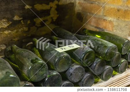 Dusty wine bottles aging in an old Znojmo cellar 138611708
