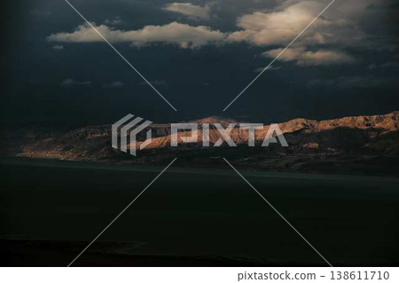 Dramatic desert coastline landscape with storm clouds over calm sea Dramatic desert coastline landscape with storm clouds over calm sea 138611710