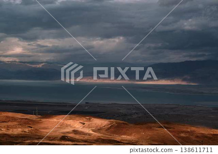 Dramatic desert coastline landscape with storm clouds over calm sea Dramatic desert coastline landscape with storm clouds over calm sea 138611711