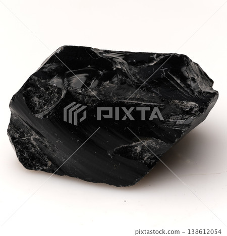 Large Polished Black Obsidian Stone with Sharp Conchoidal Fractures and Glossy Texture on a Plain White Background. Large Polished Black Obsidian Stone with Sharp Conchoidal Fractures and Glossy Texture on a Plain White Background. 138612054