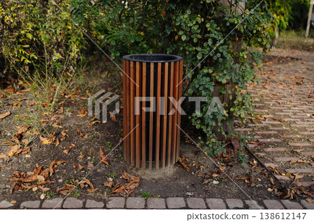 Empty park bench along paved pathway in green park 138612147