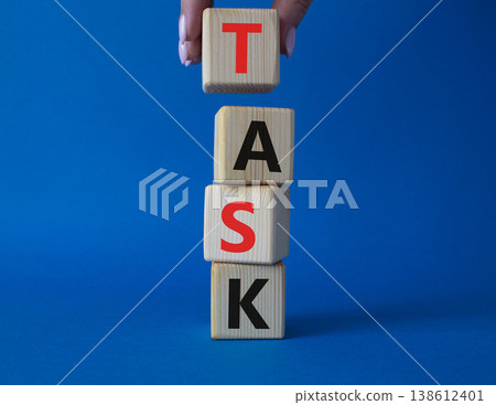 Task symbol. Concept word Task on wooden cubes. Businessman hand. Beautiful grey background. Business and Task concept. Copy space. Task symbol. Concept word Task on wooden cubes. Businessman hand. Beautiful grey background. Business and Task concept. Copy space. 138612401