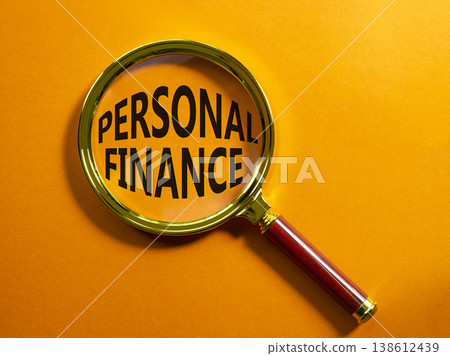 Personal Finance symbol. Magnifying Glass with words Personal Finance. Beautiful orange background. Business and Personal Finance concept. Copy space. 138612439
