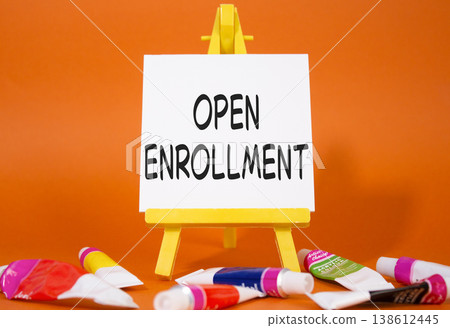 Open Enrollment symbol. Wooden blocks with words Open Enrollment. Beautiful orange background with paints and easel. Business and Open Enrollment concept. Copy space. Open Enrollment symbol. Wooden blocks with words Open Enrollment. Beautiful orange background with paints and easel. Business and Open Enrollment concept. Copy space. 138612445