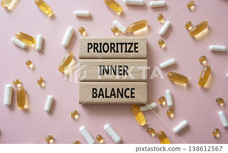 Prioritize inner balance symbol. Concept words Prioritize inner balance on wooden blocks. Beautiful pink background with pills. Healthcare and Prioritize inner balance concept. Copy space. Prioritize inner balance symbol. Concept words Prioritize inner balance on wooden blocks. Beautiful pink background with pills. Healthcare and Prioritize inner balance concept. Copy space. 138612567