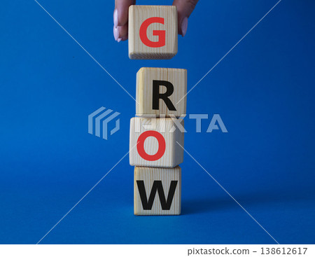 Grow symbol. Concept word Grow on wooden cubes. Beautiful blue background. Businessman hand. Business and Grow concept. Copy space. Grow symbol. Concept word Grow on wooden cubes. Beautiful blue background. Businessman hand. Business and Grow concept. Copy space. 138612617