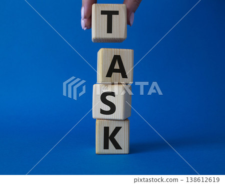 Task symbol. Concept word Task on wooden cubes. Businessman hand. Beautiful grey background. Business and Task concept. Copy space. 138612619