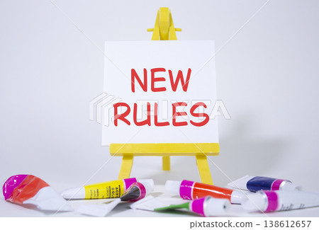 New rules symbol. Concept word Manage stress on wooden blocks. Beautiful yellow background with paints and easel. Business and New rules concept. Copy space New rules symbol. Concept word Manage stress on wooden blocks. Beautiful yellow background with paints and easel. Business and New rules concept. Copy space 138612657