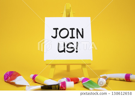 Join us symbol. Concept word Join us on wooden blocks. Beautiful yellow background with paints and easel. Business and Join us concept. Copy space Join us symbol. Concept word Join us on wooden blocks. Beautiful yellow background with paints and easel. Business and Join us concept. Copy space 138612658