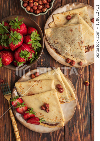 Crepes with chocolate hazelnut spread, strawberries and hazelnuts 138612711