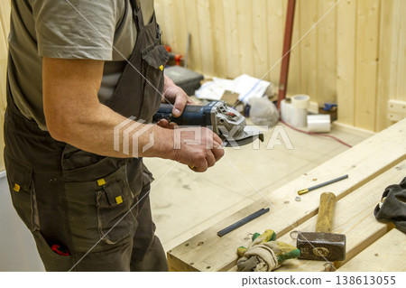 The image shows a woodworking workshop scene with raw lumber pieces scattered on a workbench covered in sawdust, showcasing the process of constructing a mortise and tenon joint. 138613055
