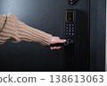 A woman opens a modern smart door lock with a digital keypad and biometric fingerprint access. 138613063