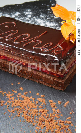 Sachertorte slice featuring rich chocolate ganache, apricot jam layers, and elegant calligraphy Sachertorte slice featuring rich chocolate ganache, apricot jam layers, and elegant calligraphy 138613095