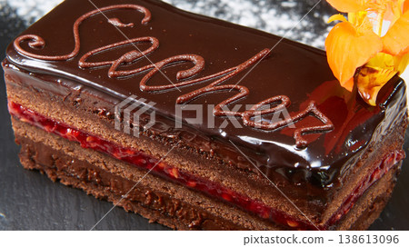 Sachertorte slice featuring rich chocolate ganache, apricot jam layers, and elegant calligraphy 138613096