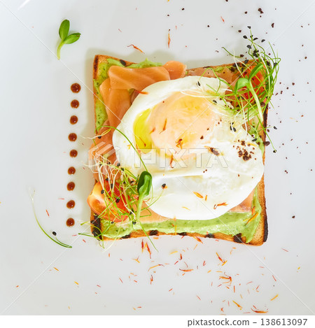 Premium avocado toast topped with a poached egg, smoked salmon, and fresh sprouts Premium avocado toast topped with a poached egg, smoked salmon, and fresh sprouts 138613097