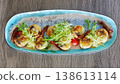 A multi-sensory gourmet appetizer featuring seared scallops with melted cheese 138613114
