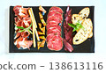 A multi-sensory charcuterie board featuring premium sliced salami, prosciutto 138613116