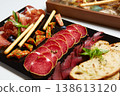 A multi-sensory charcuterie board featuring premium sliced salami, prosciutto 138613120