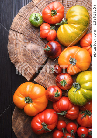 Colorful heirloom tomatoes arranged on round wooden board Colorful heirloom tomatoes arranged on round wooden board 138613155