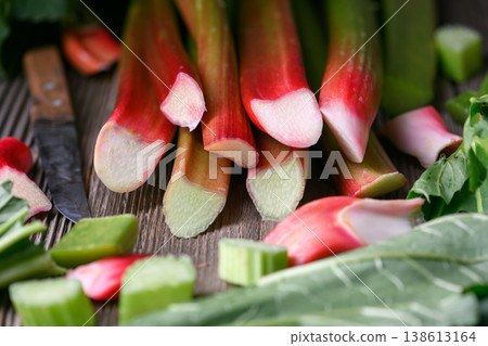 Fresh rhubarb stalks arranged with green leaves Fresh rhubarb stalks arranged with green leaves 138613164