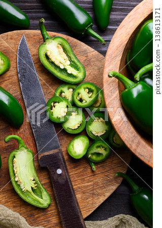 Jalapeno peppers on wooden board with knife Jalapeno peppers on wooden board with knife 138613171