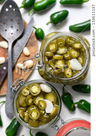 Top view of jars with pickled jalapeno slices and garlic cloves Top view of jars with pickled jalapeno slices and garlic cloves 138613197