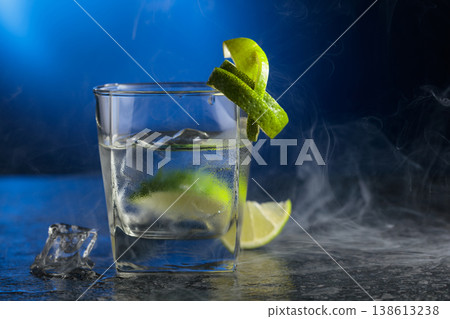 Vodka with lime and ice cubes in a fogged up glass. 138613238