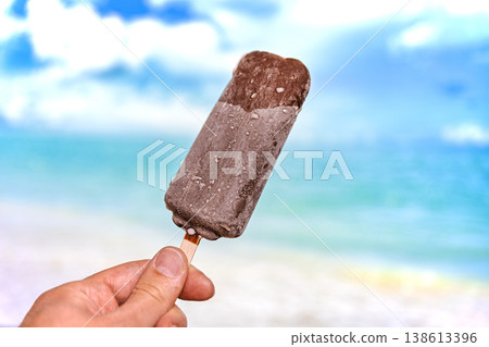 Chocolate Ice Cream Bar on a Stick with Tropical Beach Background 138613396