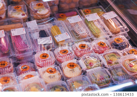 Assorted Pastries and Cakes with Discount Stickers in a Supermarket Display 138613433