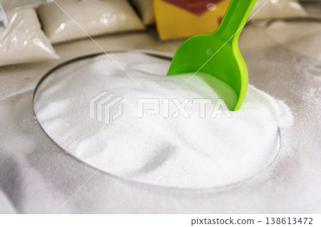 White granulated sugar in a bulk bin with a green plastic scoop White granulated sugar in a bulk bin with a green plastic scoop 138613472