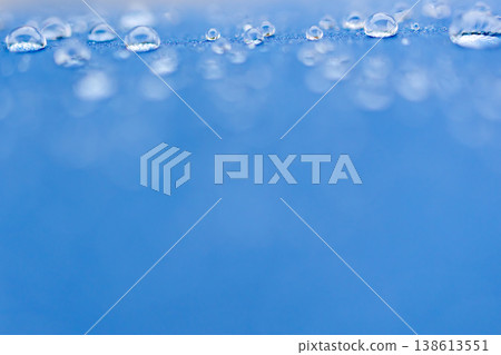 Raindrops lined up on a blue umbrella Raindrops lined up on a blue umbrella 138613551