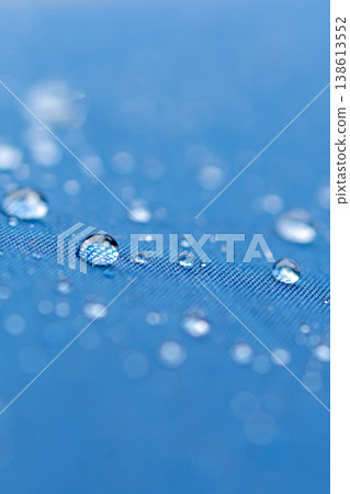 Water droplets on a water-repellent blue umbrella - vertical 138613552