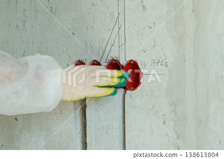 An electrician carefully installs electrical outlets into a concrete wall An electrician carefully installs electrical outlets into a concrete wall 138613804