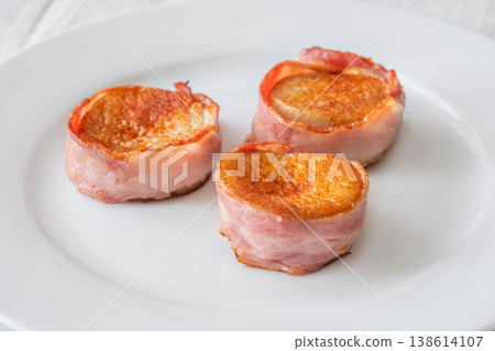King oyster mushrooms wrapped in crispy bacon served as elegant gourmet appetizer on white plate King oyster mushrooms wrapped in crispy bacon served as elegant gourmet appetizer on white plate 138614107