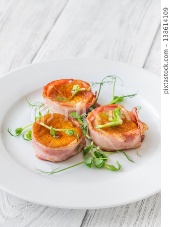 King oyster mushrooms wrapped in crispy bacon served as elegant gourmet appetizer on white plate King oyster mushrooms wrapped in crispy bacon served as elegant gourmet appetizer on white plate 138614109