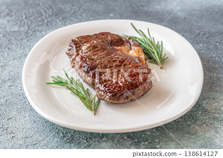 Perfectly grilled beef steak with rosemary on white plate premium restaurant presentation Perfectly grilled beef steak with rosemary on white plate premium restaurant presentation 138614127