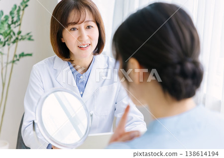一位女士正在整形外科診所接受醫生的諮詢和檢查。 138614194