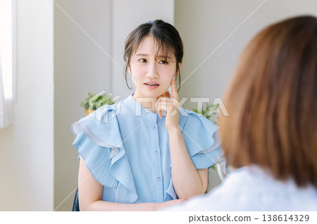 A woman receiving a consultation at a cosmetic surgery clinic. 138614329