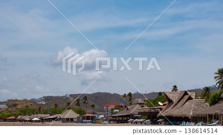 San Juan del Sur, Nicaragua - May 09, 2019: Touristic beach landscape with rustic houses. Vacation and travel. Beach landscape and house with straw roof. Travel destination. Touristic place San Juan del Sur, Nicaragua - May 09, 2019: Touristic beach landscape with rustic houses. Vacation and travel. Beach landscape and house with straw roof. Travel destination. Touristic place 138614514