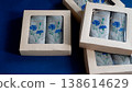 Linen napkins featuring delicate blue cornflower embroidery in eco-friendly craft paper boxes. Elegant embroidered textile accessories 138614629