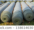 Large rolls of professional artificial turf stored outdoors for a sports field installation or renovation project 138614630