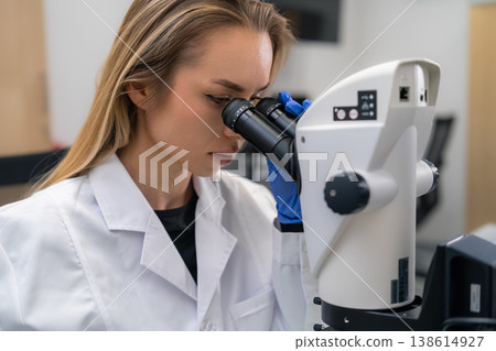 Conducting analysis of biological specimens through a precision microscope at a research facility. Conducting analysis of biological specimens through a precision microscope at a research facility. 138614927