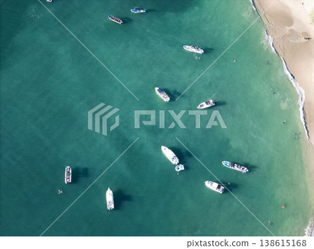 Boats floating in clear water near sandy beach at midday Boats floating in clear water near sandy beach at midday 138615168