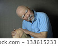 A bearded old man suffering from knee pain 138615233