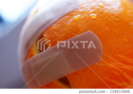 dissected damaged cut orange stuck with a plaster and dressing dissected damaged cut orange stuck with a plaster and dressing 138615606