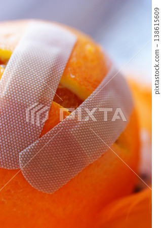 dissected damaged cut orange stuck with a plaster and dressing dissected damaged cut orange stuck with a plaster and dressing 138615609