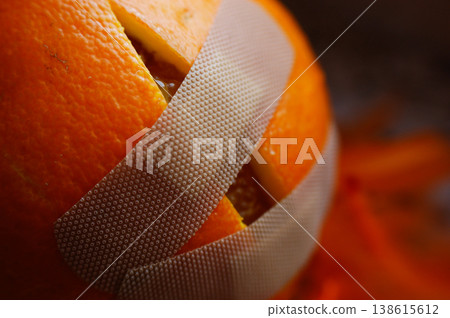 dissected damaged cut orange stuck with a plaster and dressing dissected damaged cut orange stuck with a plaster and dressing 138615612