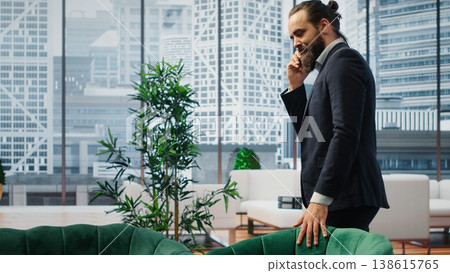 CEO multitasking and managing an important phone call with investors while he reviews financial reports on his laptop. Strategic decision making in corporate life at the workplace. Camera B. CEO multitasking and managing an important phone call with investors while he reviews financial reports on his laptop. Strategic decision making in corporate life at the workplace. Camera B. 138615765