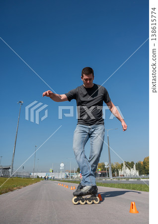 A Caucasian man rollerblades around the slalom course. 138615774