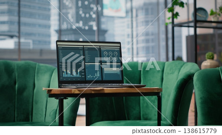 Big data reports and graphics showcasing business corporation success, empty luxurious office with a laptop on the table. Professional workspace with pc display running trends. Big data reports and graphics showcasing business corporation success, empty luxurious office with a laptop on the table. Professional workspace with pc display running trends. 138615779